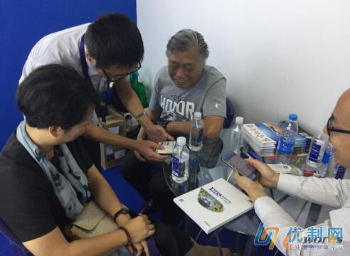 优制网负责人韩总向参展人员演示优制网APP