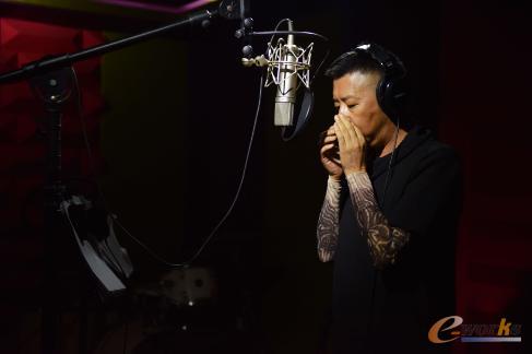 彝族知名歌手吉克曲布在录音室吹奏口弦